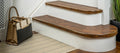 Wood-effect flexible stair nosing installed on curved and straight steps, enhancing traditional interiors by Premier Trims.