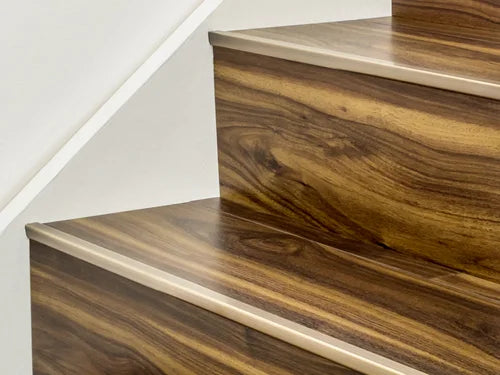 Solid brass stair edge trim on wood-effect steps from Premier Trims. Custom-made for durable and elegant flooring transitions.