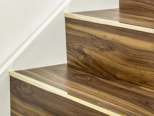 Solid brass stair edge trim on wood-effect steps from Premier Trims. Custom-made for durable and elegant flooring transitions.