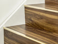 Premier Trims solid brass stair lips on wooden stairs. Enhances safety and style with made-to-order flooring edge solutions.