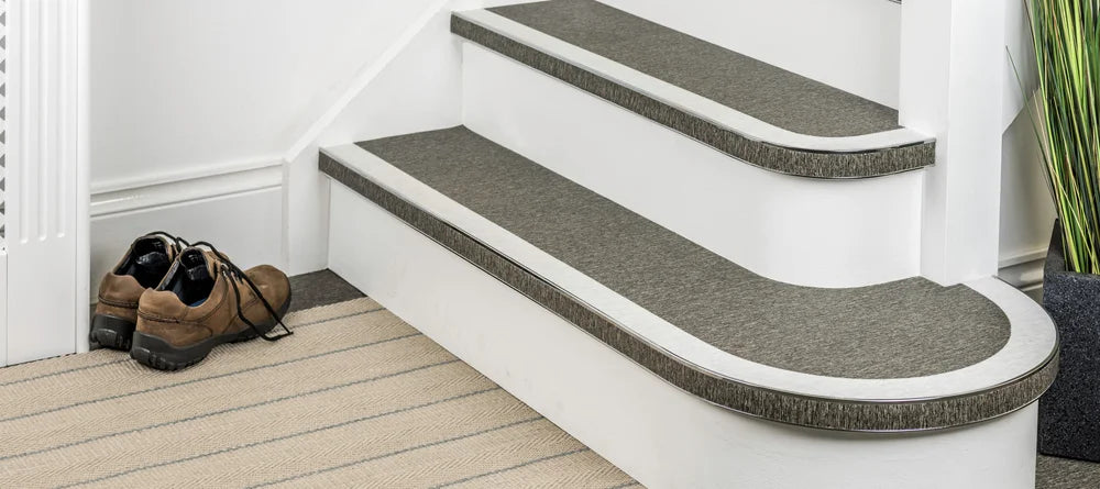 Flexible stair nosing in grey finish installed on curved and straight steps, ideal for modern interiors by Premier Trims.
