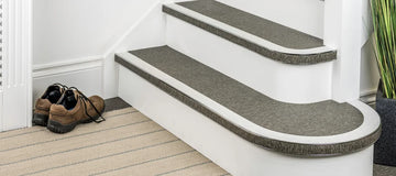 Flexible stair nosing in grey finish installed on curved and straight steps, ideal for modern interiors by Premier Trims.