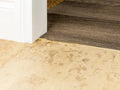 Low-profile solid brass transition strip connecting tile to wood flooring for smooth, durable floor transitions.