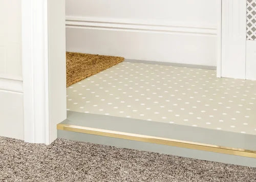 Solid brass flooring edge trim between carpet and vinyl flooring. Premier Trims solution for seamless room transitions.