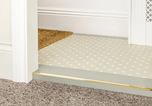 Custom Premier Trims brass door bar joining carpet and polka-dot vinyl. Ideal for stylish and functional flooring edges.
