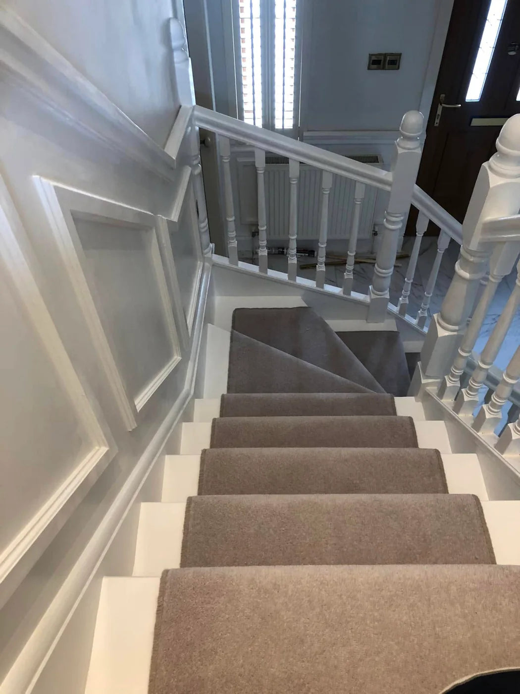 Completed fitted carpet installation on a bright residential staircase