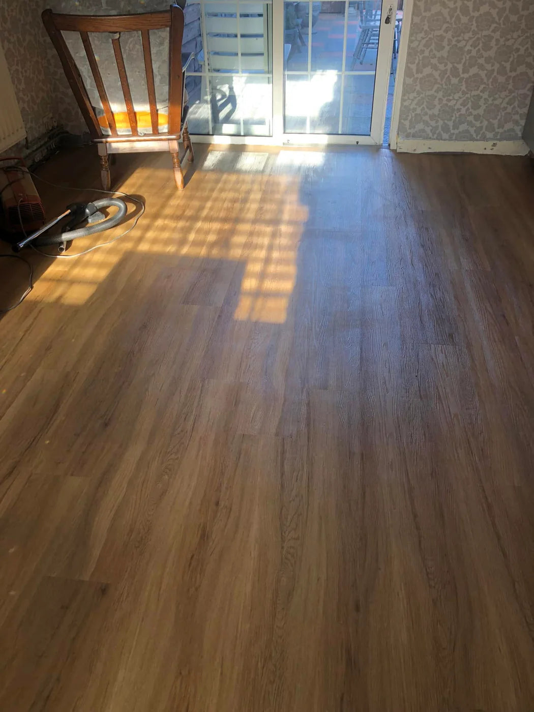 Completed wood-effect LVT installation in a bright living space