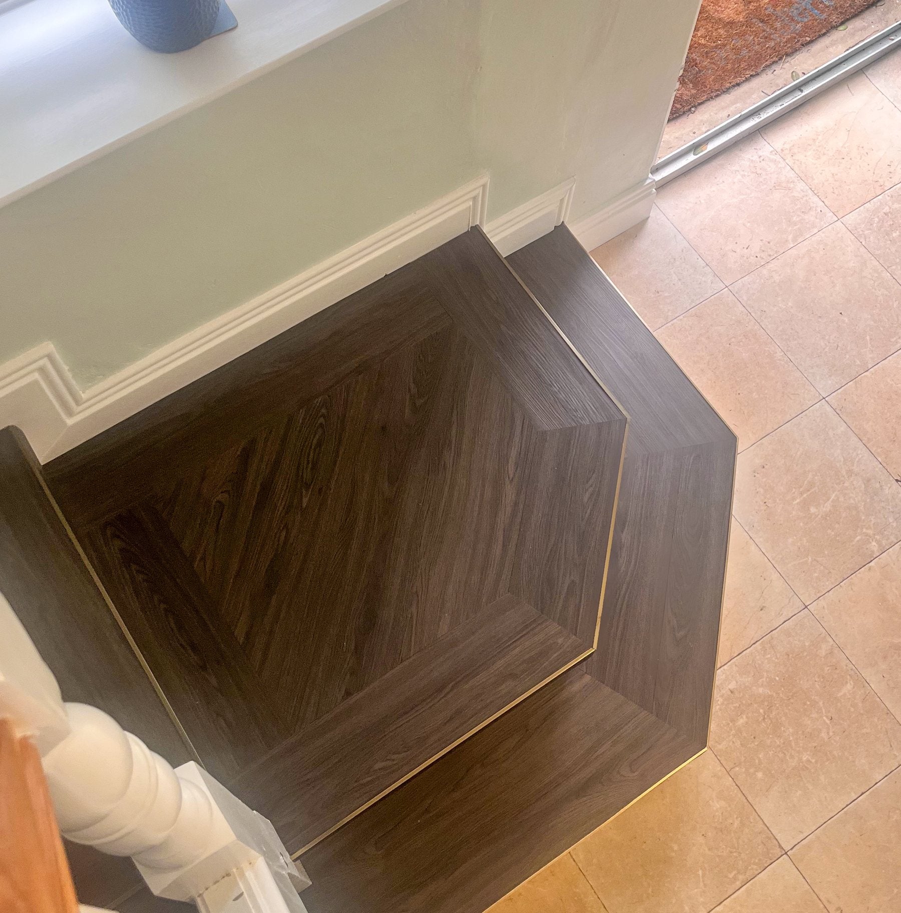 Dark LVT stair step with brass trim detail